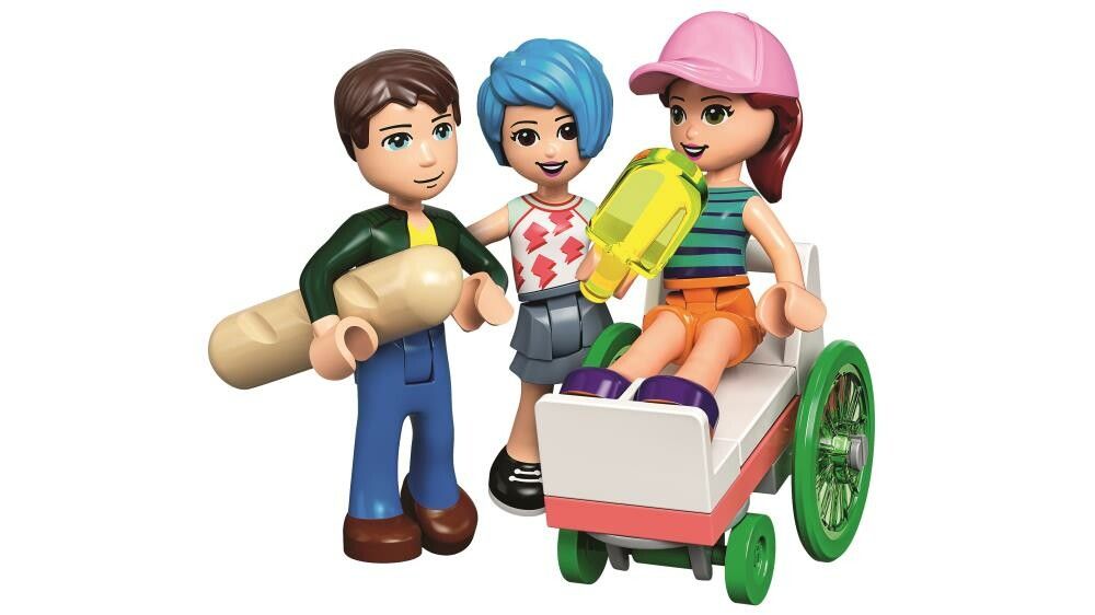 Tre minifigure LEGO. Una figura tiene in mano una baguette, un'altra una pistola ad acqua. Una figura è seduta su una sedia a rotelle. Tutte le figure sono in plastica e hanno acconciature e abiti diversi.