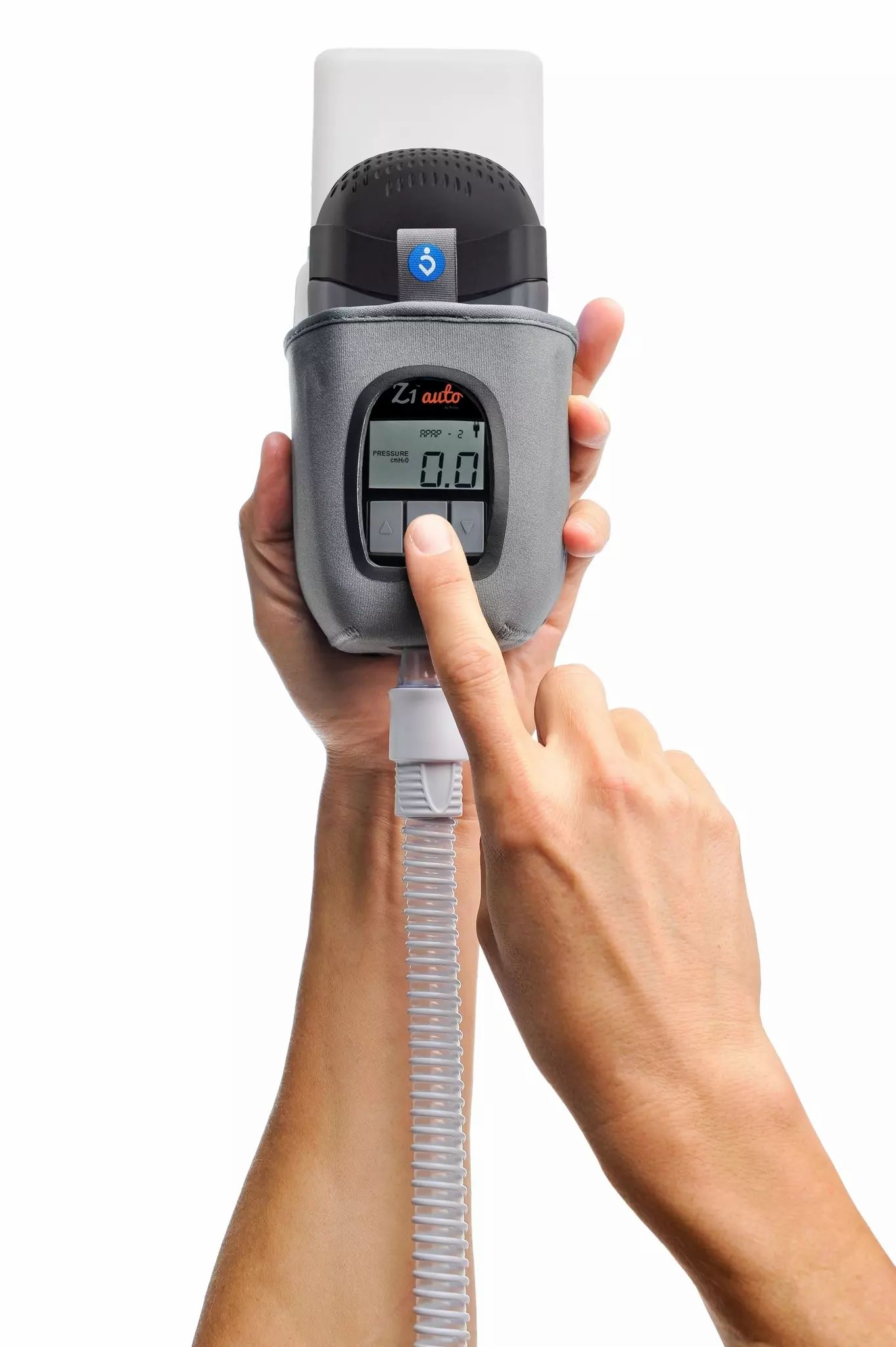 Dispositivo CPAP da viaggio grigio con display e tubi, tenuto da mani.