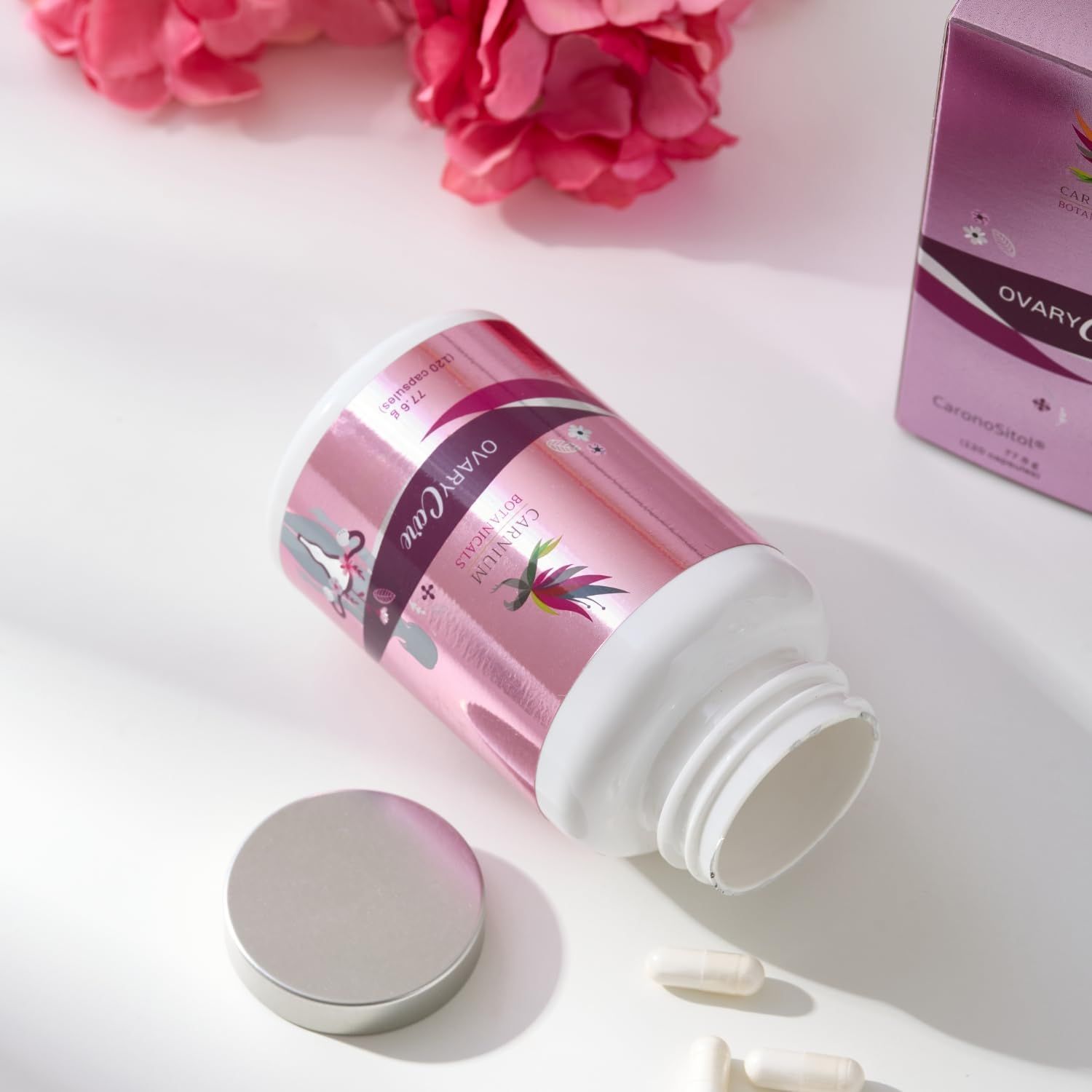 Flacone con etichetta rosa, aperto, con capsule accanto. Scritta: CARNIUM BOTANICALS, OVARY Care.