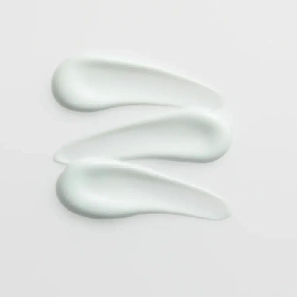 Tre strisce di crema su sfondo chiaro. Visibile la consistenza della crema.