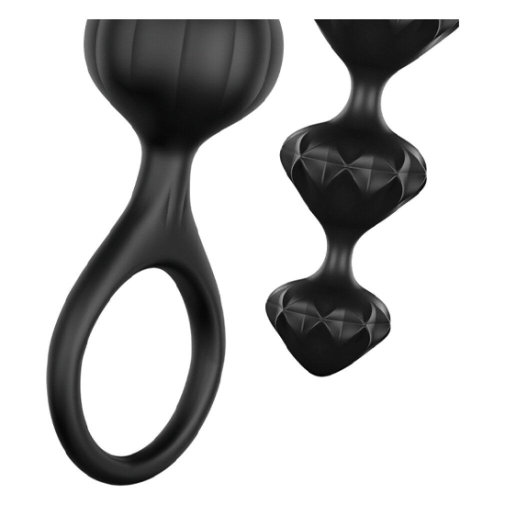 Primo piano di due sfere nere. Una con anello, l'altra con motivo a diamante.