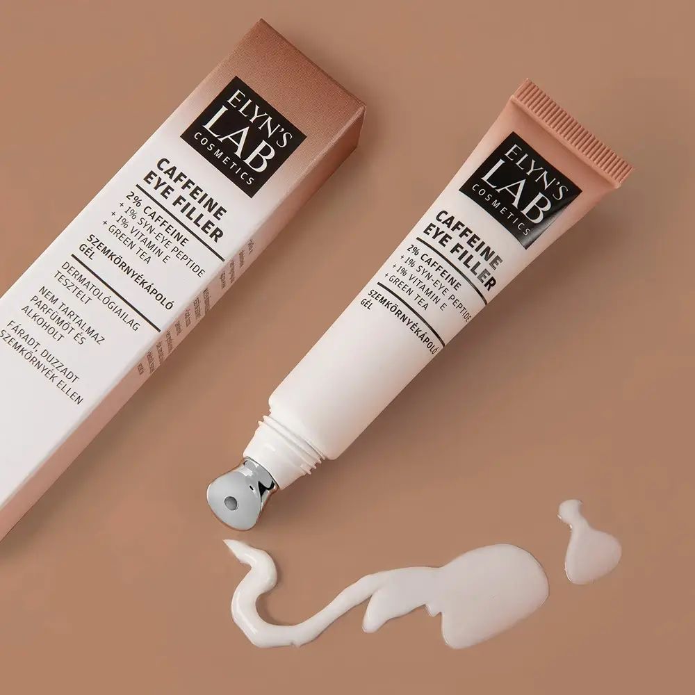Tubo e confezione di crema. Scritta: ELYN'S LAB Caffeine Eye Filler. Con applicatore roll-on. Macchia di crema.