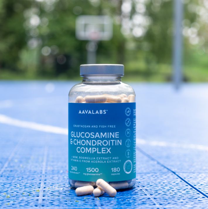 Bottiglia di capsule di glucosamina su un campo sportivo.