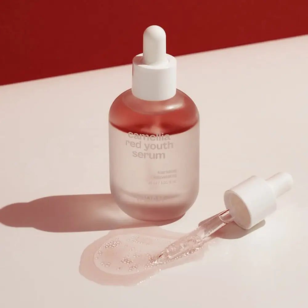 Flacone di siero con pipetta e goccia di siero. Scritta: Camellia Red Youth Serum. Marchio YADAH.