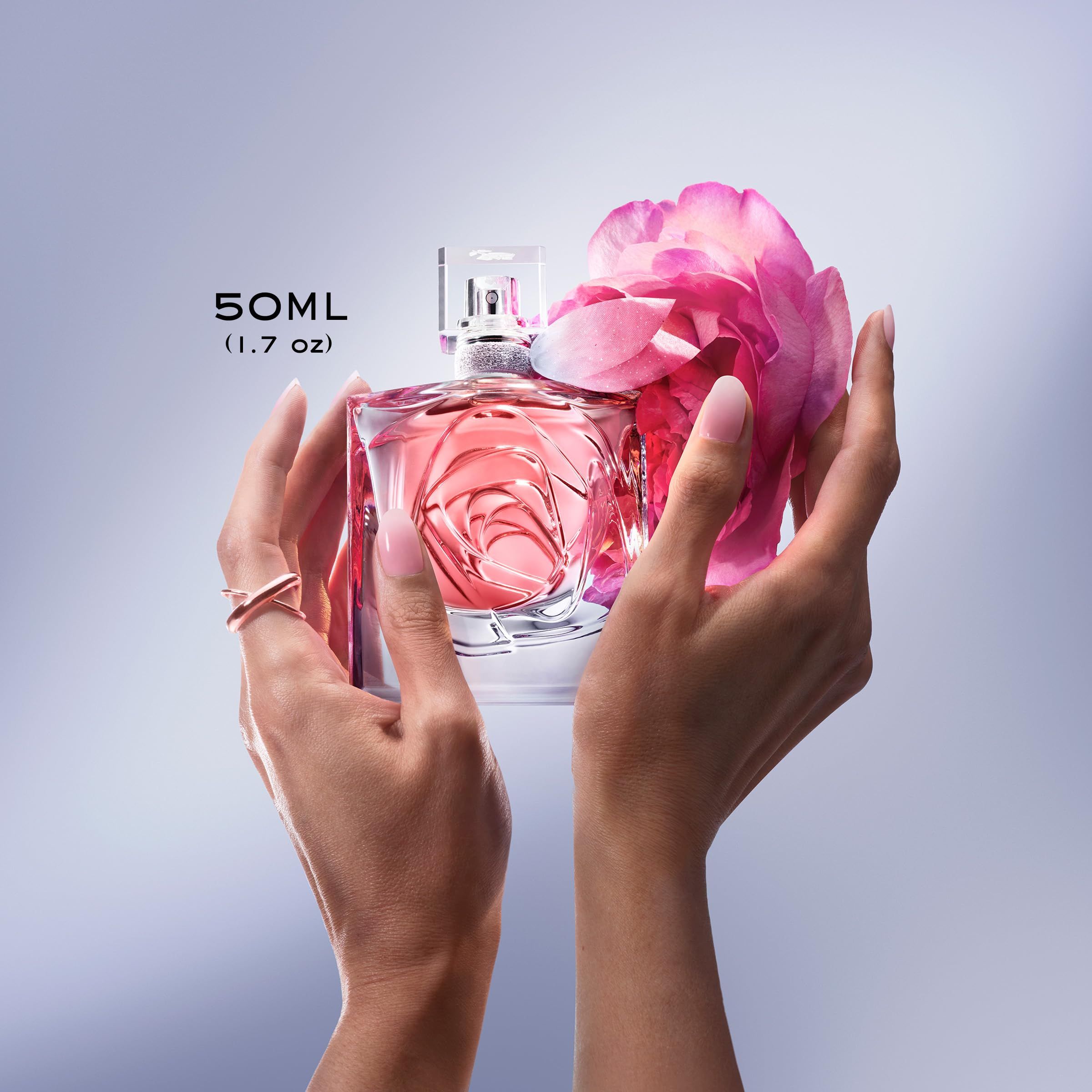 Mani che tengono un flacone rosa con decorazione a petali. Testo: 50ml (1.7 oz). Anello al dito.