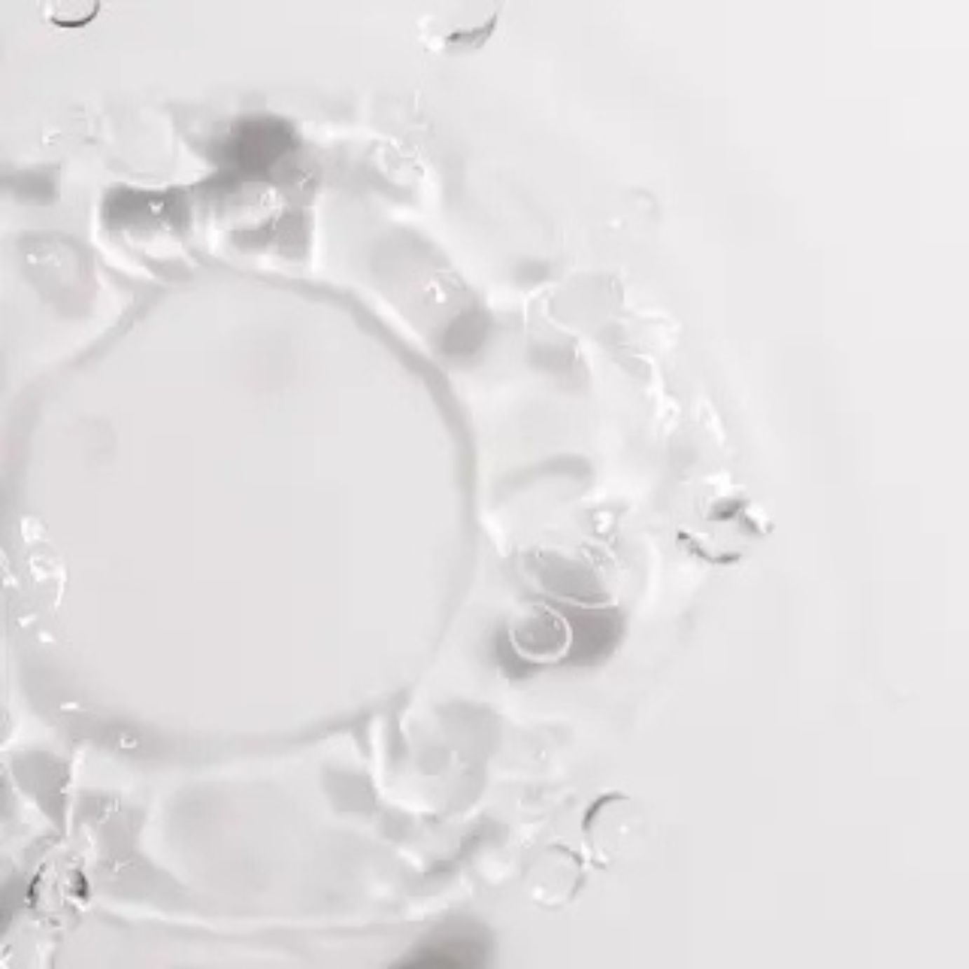Primo piano dell'acqua. Disposizione circolare delle increspature dell'acqua. Sfondo bianco.