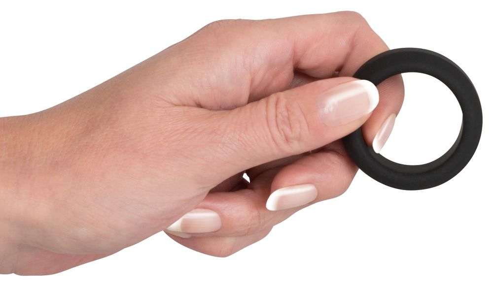 Mano che tiene un anello per pene in silicone nero.
