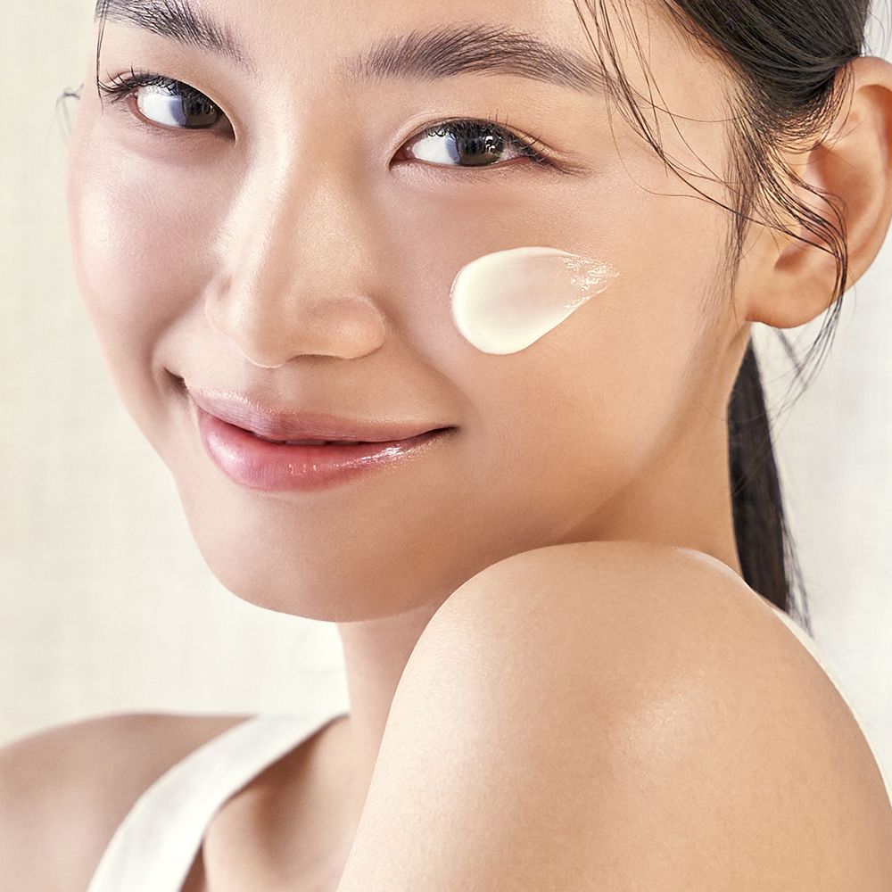 Viso di una donna con una macchia di PURITO Wonder Releaf Centella Daily Sun Lotion.