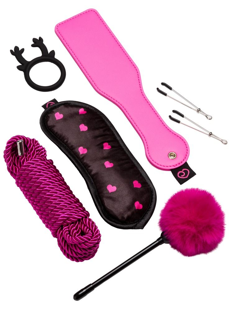 Un set di sette articoli: paddle rosa, maschera per gli occhi, corda, frusta di piume, anello, morsetti per capezzoli.