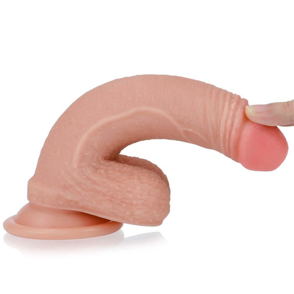 Dildo curvo, beige con punta rosa. Una mano tocca la punta. Su sfondo bianco.