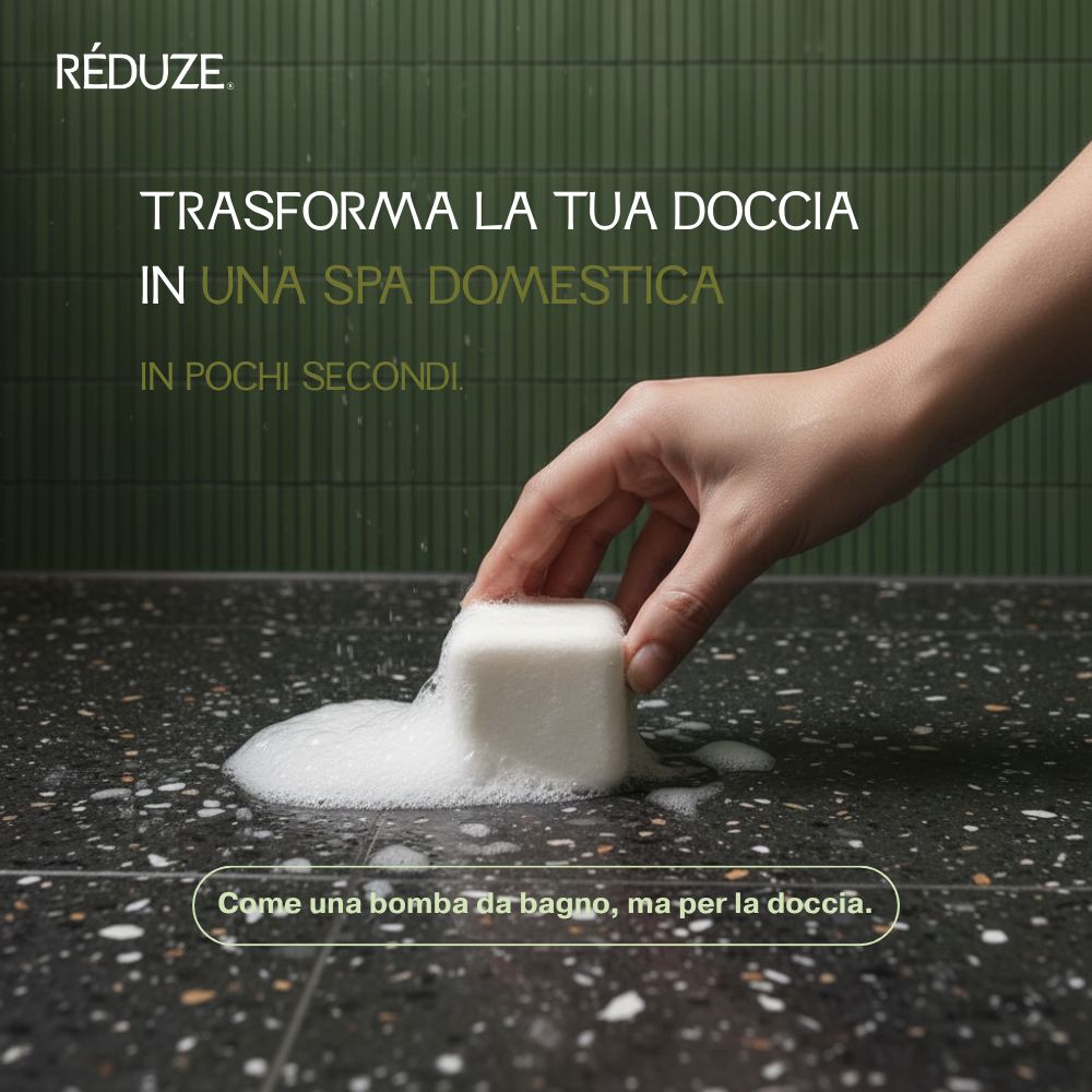 Una mano posiziona un cubo doccia bianco e quadrato su una superficie nera. Si forma schiuma.