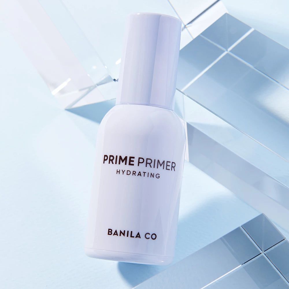 Flacone bianco con dosatore a pompa. Scritta: PRIME PRIMER HYDRATING, BANILA CO. Su sfondo blu.