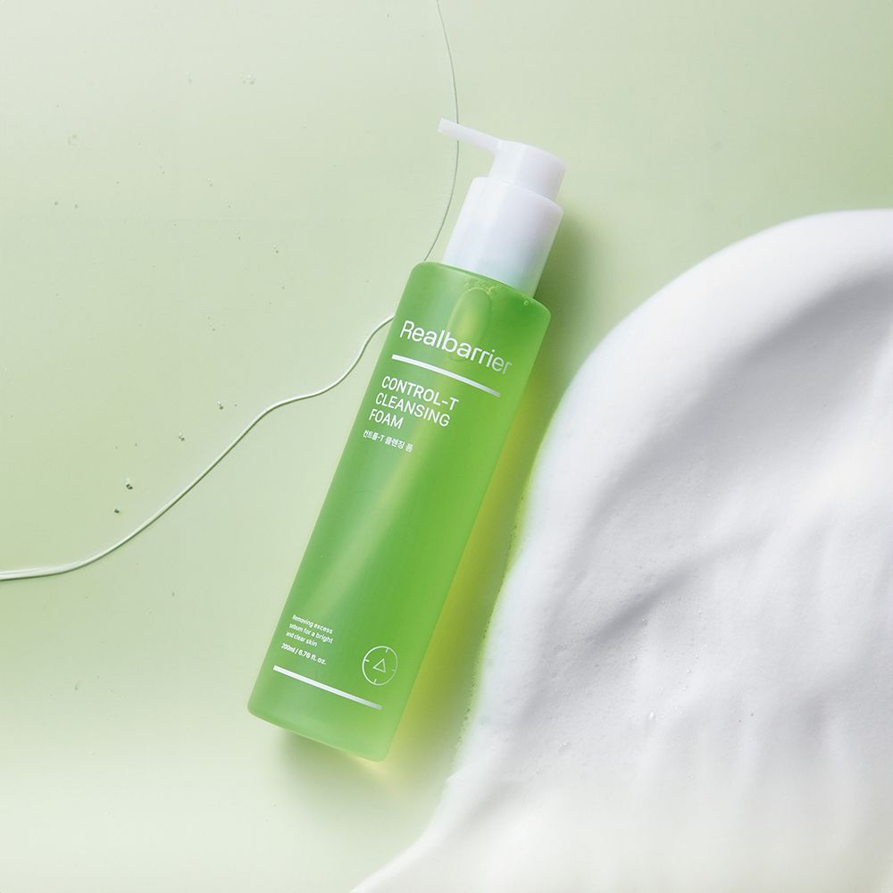 Flacone verde con erogatore bianco, leggermente inclinato. Accanto, schiuma. Scritta: Realbarrier, CONTROL-T CLEANSING FOAM.