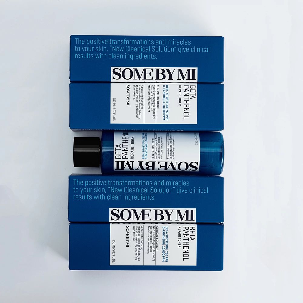 Diverse confezioni di prodotti blu con testo. Una bottiglia è posta sulle confezioni. Testo: SOME BY MI, BETA PANTHENOL REPAIR TONER.