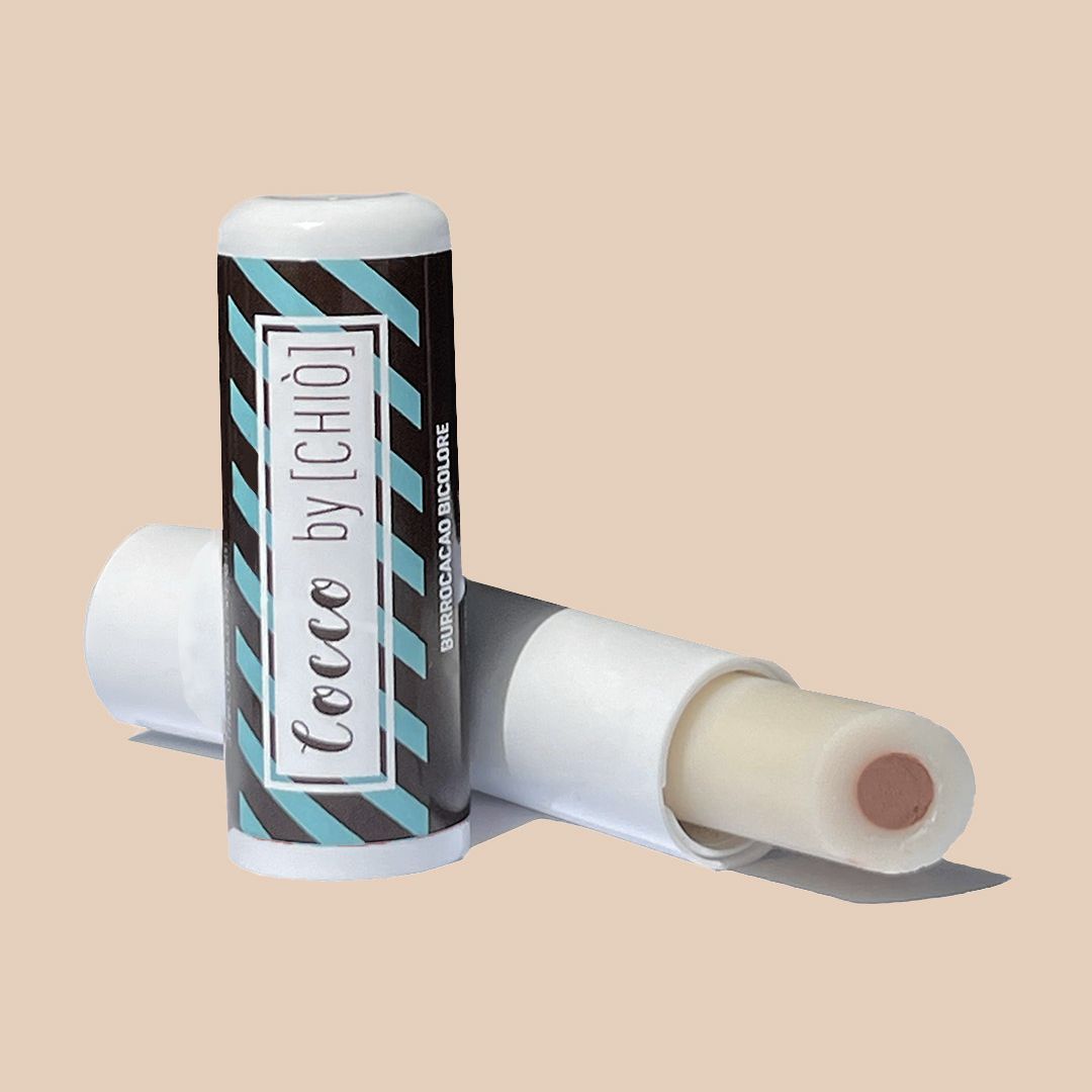 Due burrocacao. Uno aperto, mostra un cuore rosa. Confezione a strisce blu-nere e testo: Cocco by [CHIO], Burrocacao Bicolore.