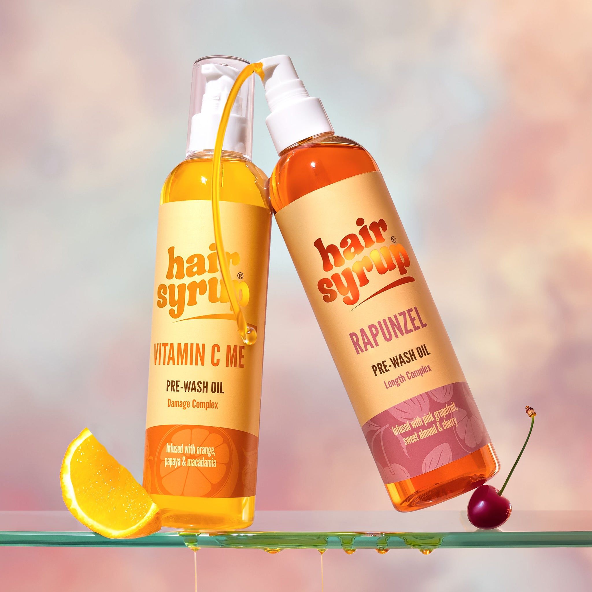 Due flaconi prodotti "Hair Syrup". "Vitamin C Me" e "Rapunzel". Pre-Wash Oil. Su lastra di vetro.