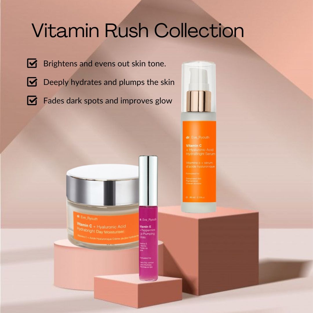 Prodotti cosmetici su piedistallo: crema, siero, lucidalabbra. Vasi di crema e siero con etichette arancioni. Lucidalabbra rosa.