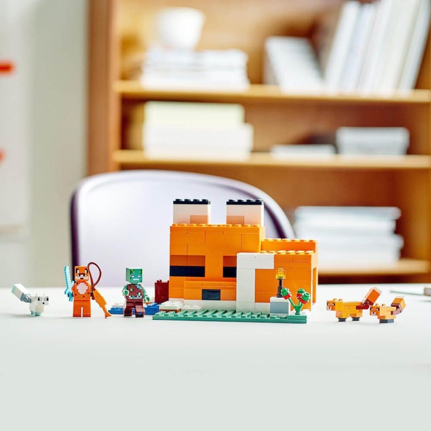 LEGO Minecraft 21178. Edificio arancione e bianco. Personaggi: volpe, zombie, volpi, volpe bianca. Posizionato su un tavolo.