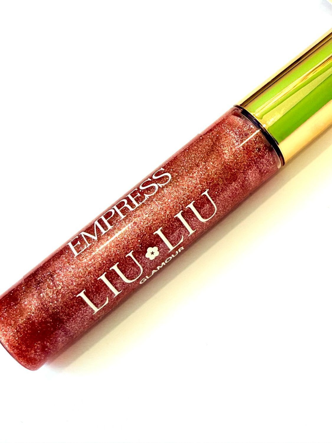 Primo piano del flacone di lucidalabbra. Scritta: EMPRESS LIU LIU Glamour. Lucidalabbra rosso glitterato.