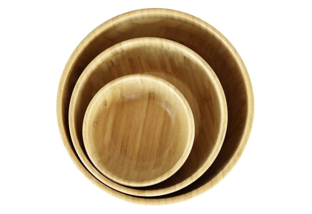 Tre ciotole rotonde in legno chiaro, impilate l'una nell'altra. Le ciotole sono viste dall'alto.