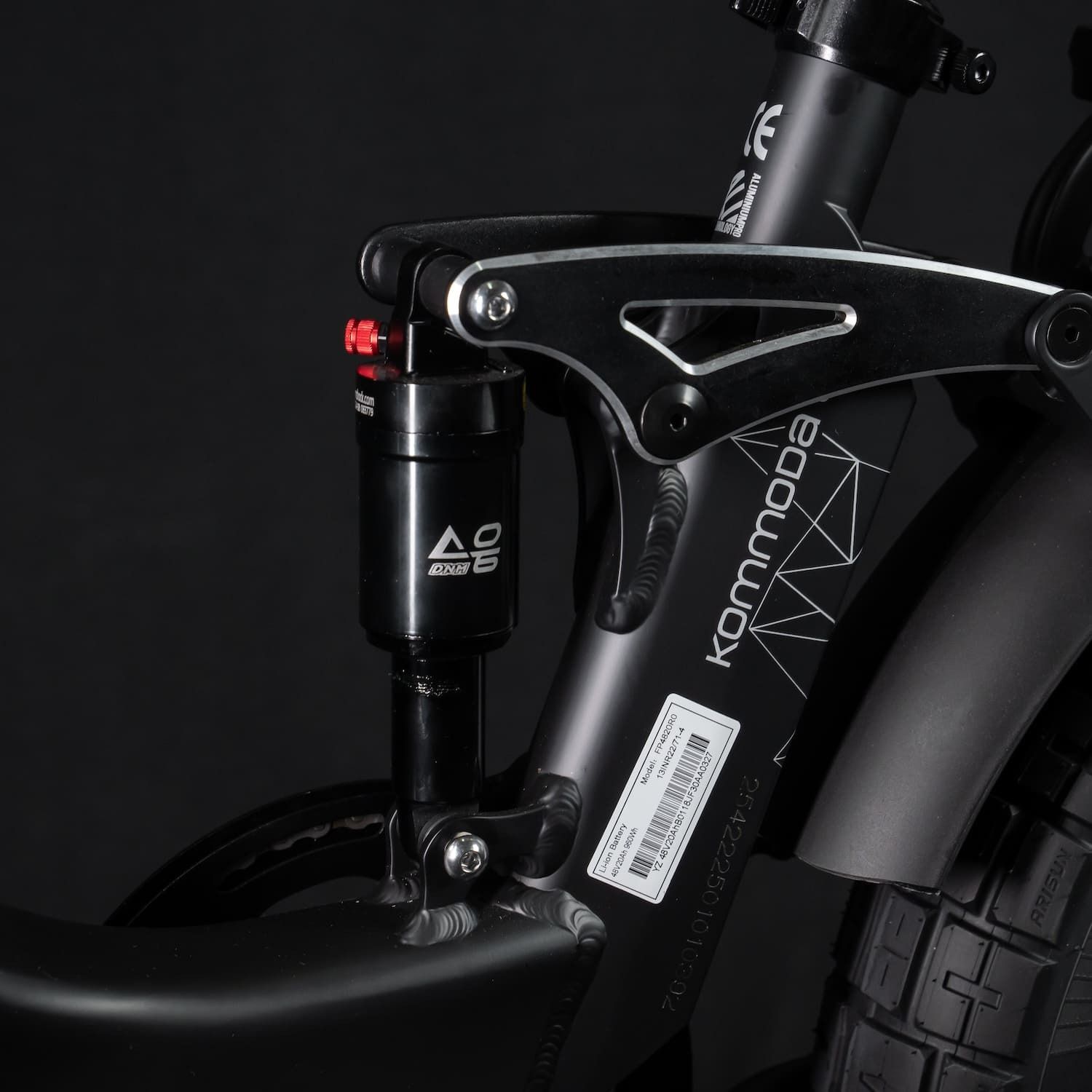 Primo piano dell'ammortizzatore posteriore e del telaio. La parola Kommoda è visibile sul telaio.