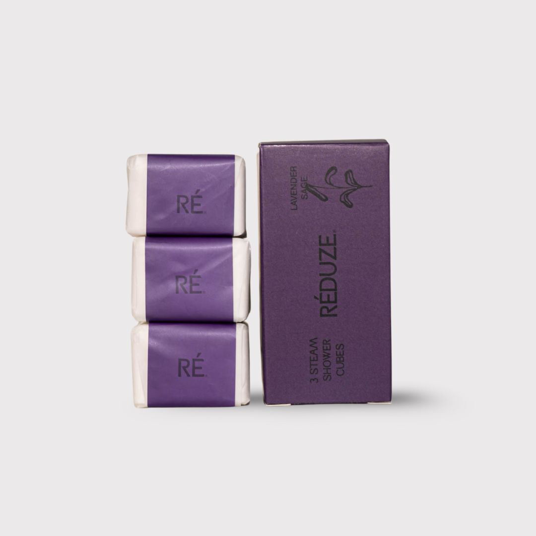 Tre cubetti doccia avvolti in carta, accanto a una scatola viola con logo RÉDUZE.