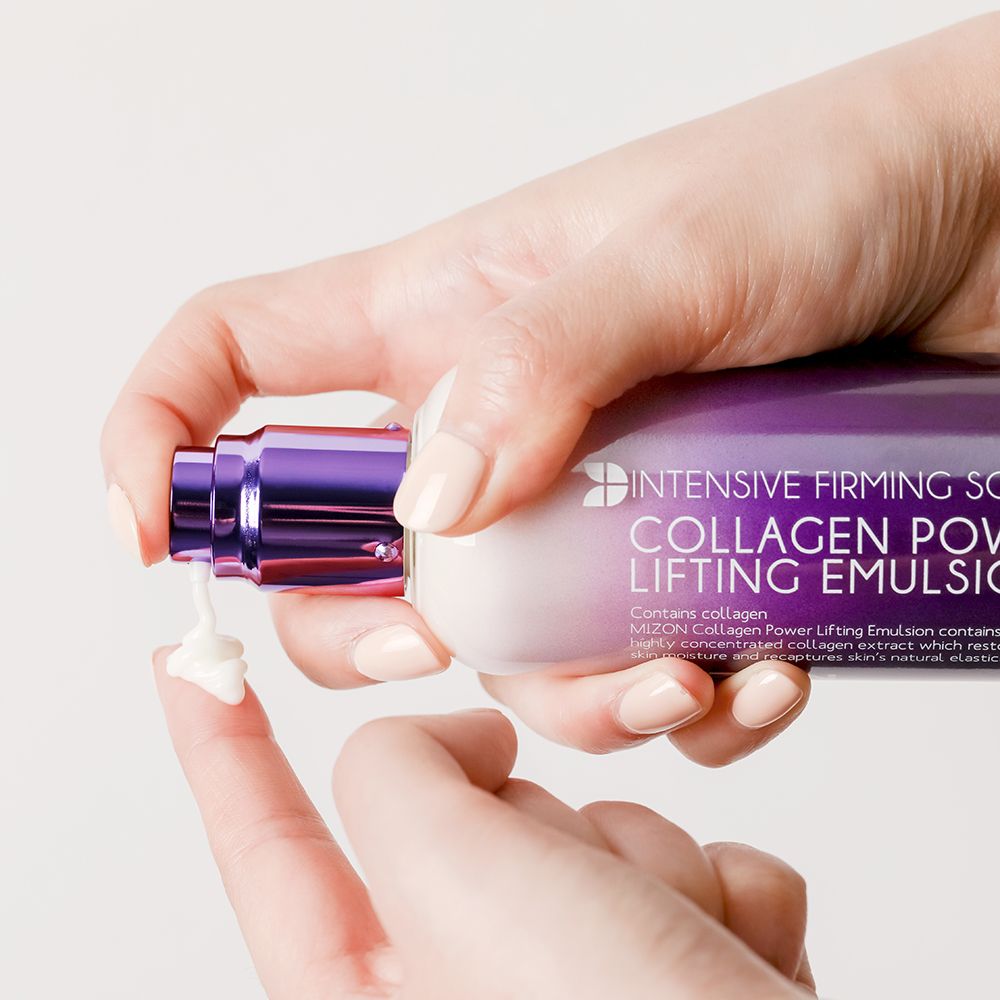 Mano che preme sulla testa a pompa del flacone MIZON Collagen Power Lifting Emulsion. Crema erogata.