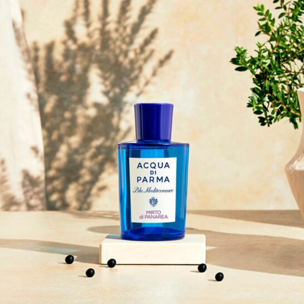 Flacone di profumo blu su un piedistallo. Scritta: ACQUA DI PARMA Blu Mediterraneo Mirto di Panarea. Con decorazioni.