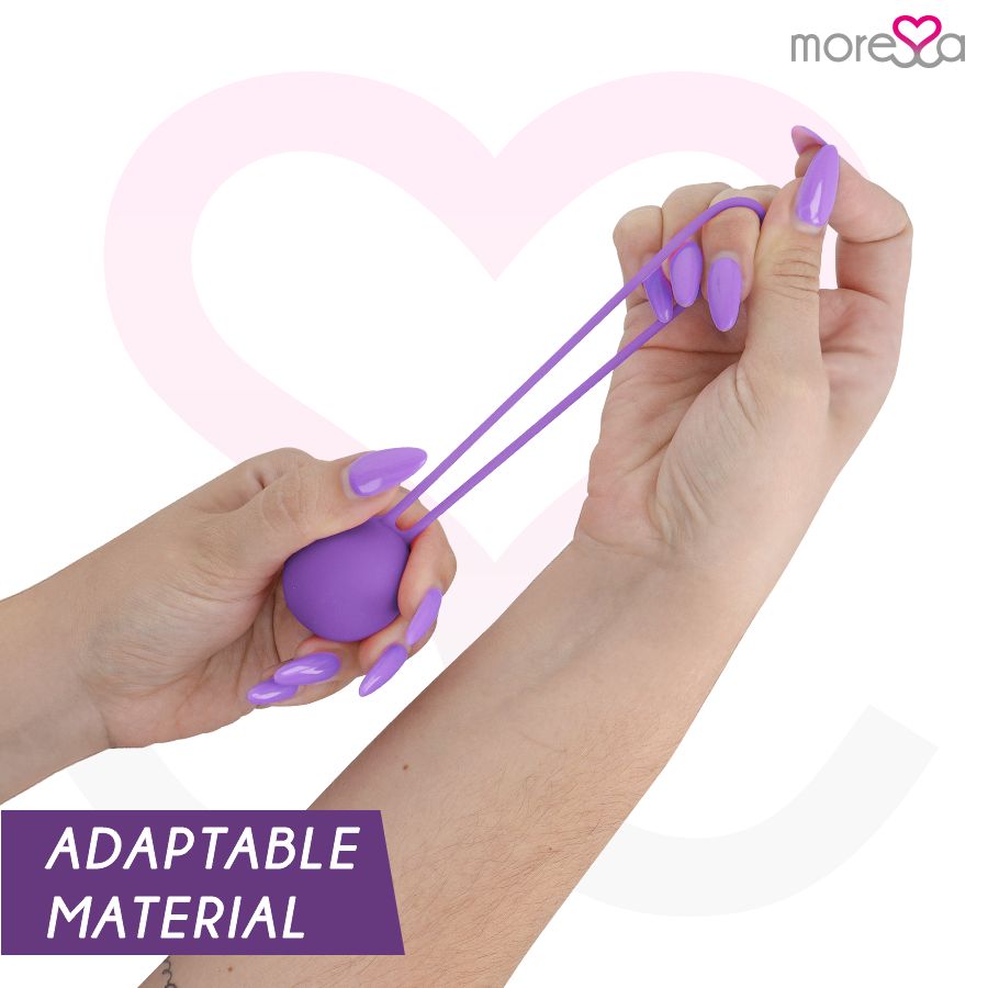 Mani che tengono una palla per esercizi di Kegel lilla in silicone. Testo: ADAPTABLE MATERIAL.