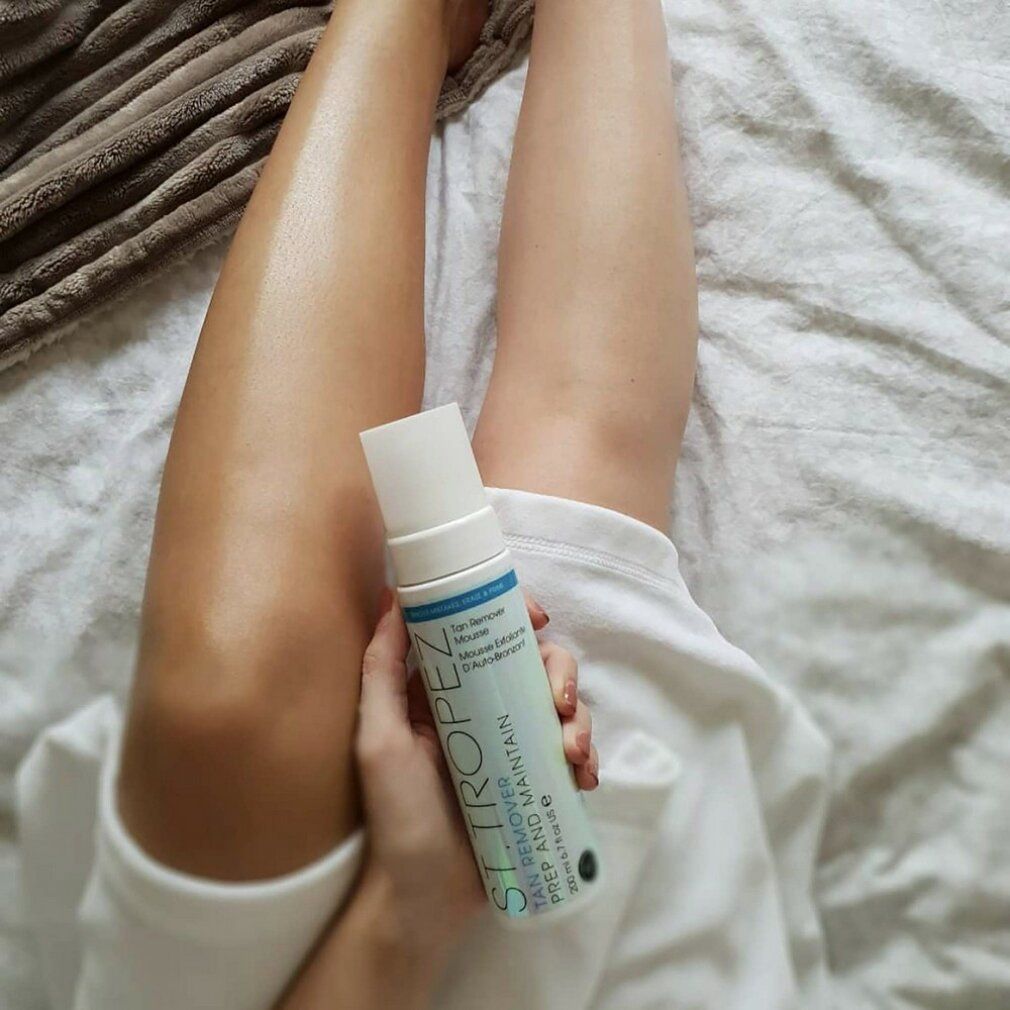 Persona tiene in mano un prodotto. Gambe abbronzate e non. Testo: ST. TROPEZ, Tan Remover Mousse.