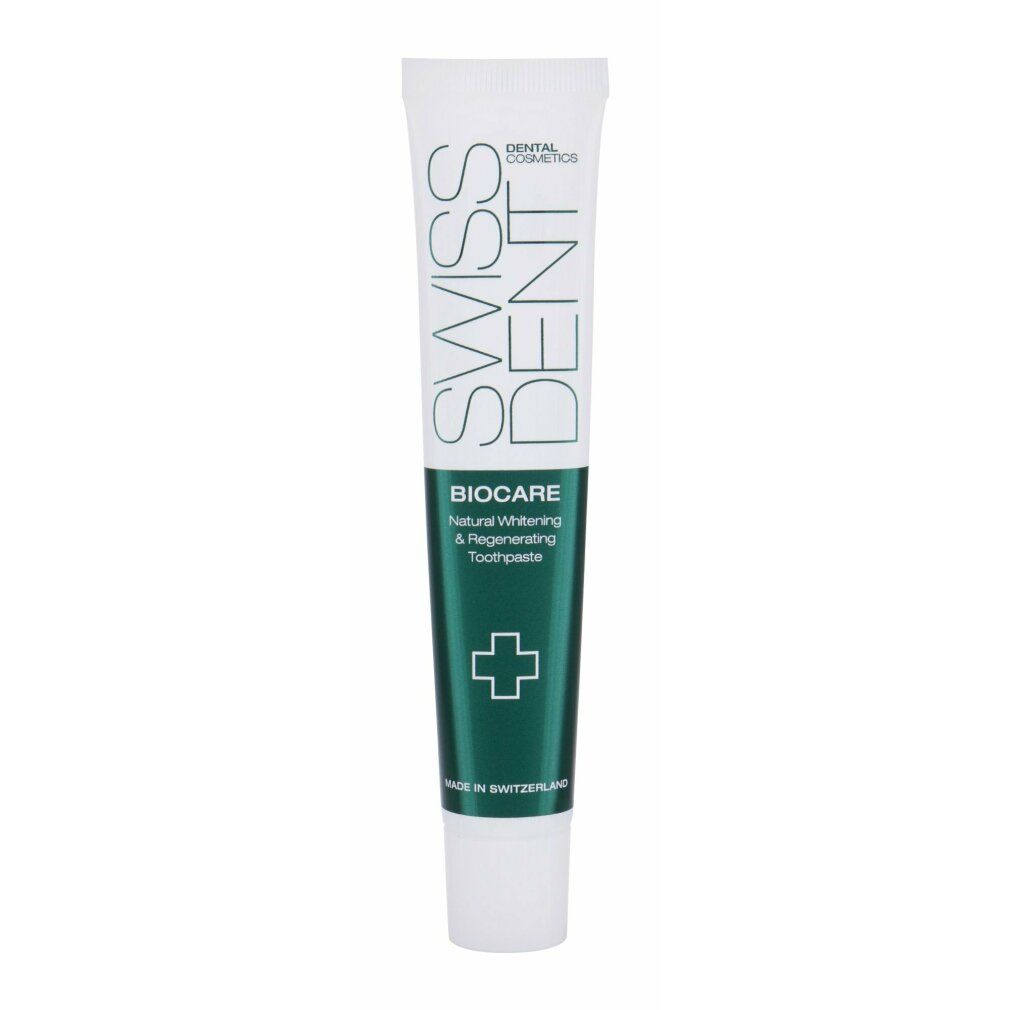 Tubo di dentifricio con banda verde. Scritta Swissdent, Biocare, Natural Whitening & Regenerating Toothpaste. Croce verde.