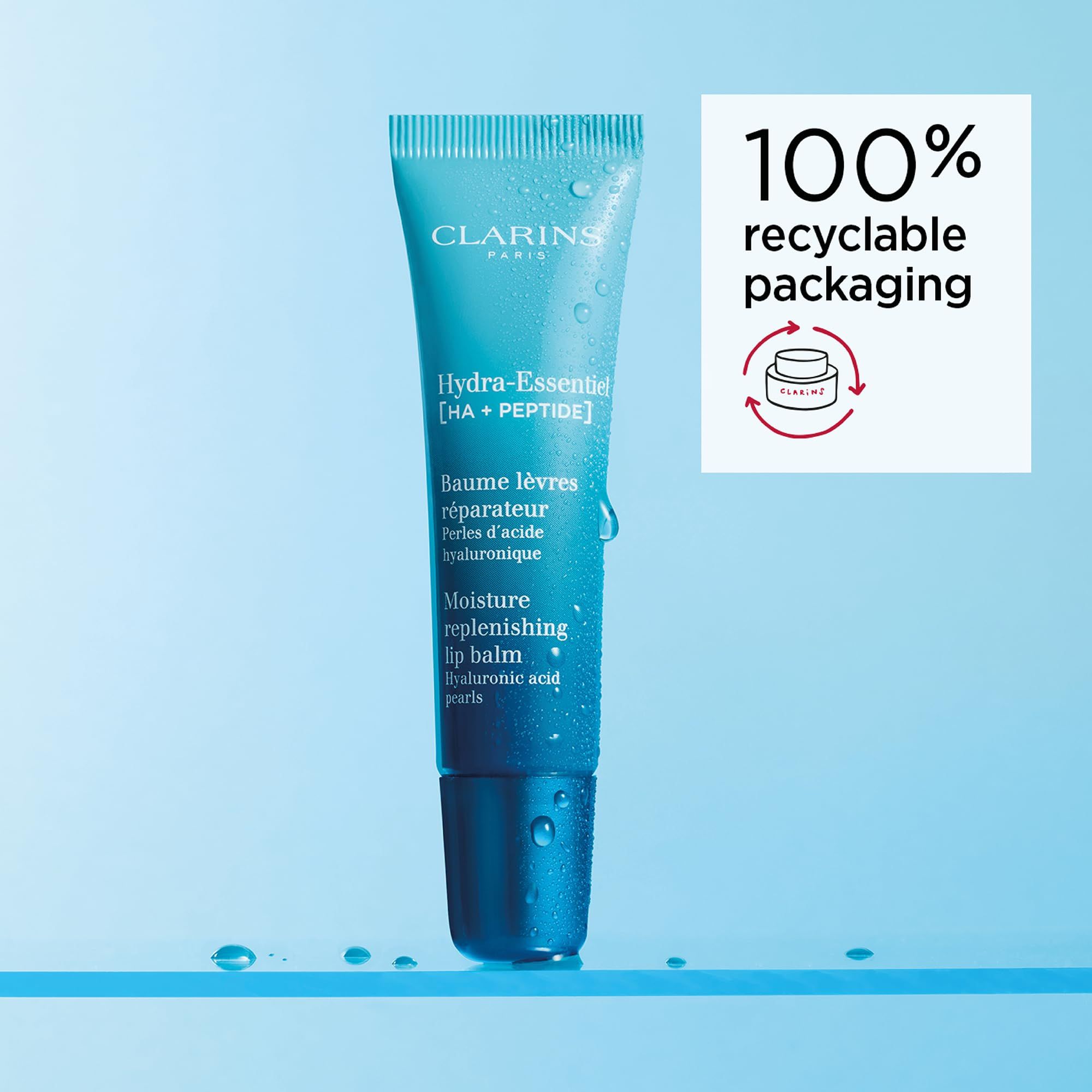 Tubo di balsamo labbra Clarins Hydra-Essentiel con confezione riciclabile al 100%. Testo: Hydra-Essentiel, Baume lèvres réparateur, Moisture replenishing lip balm.