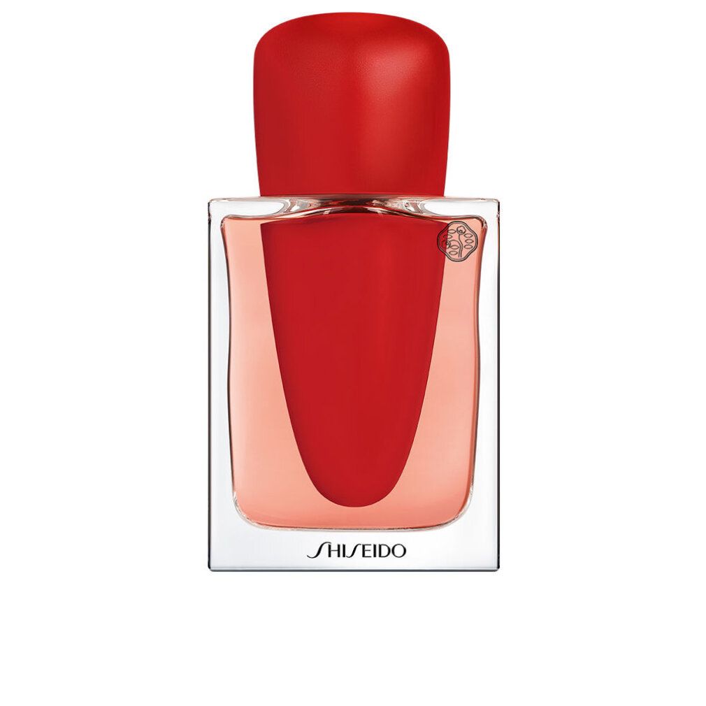 Flacone con tappo rosso e liquido rosso. Vetro trasparente. Scritto: Shiseido. Logo.