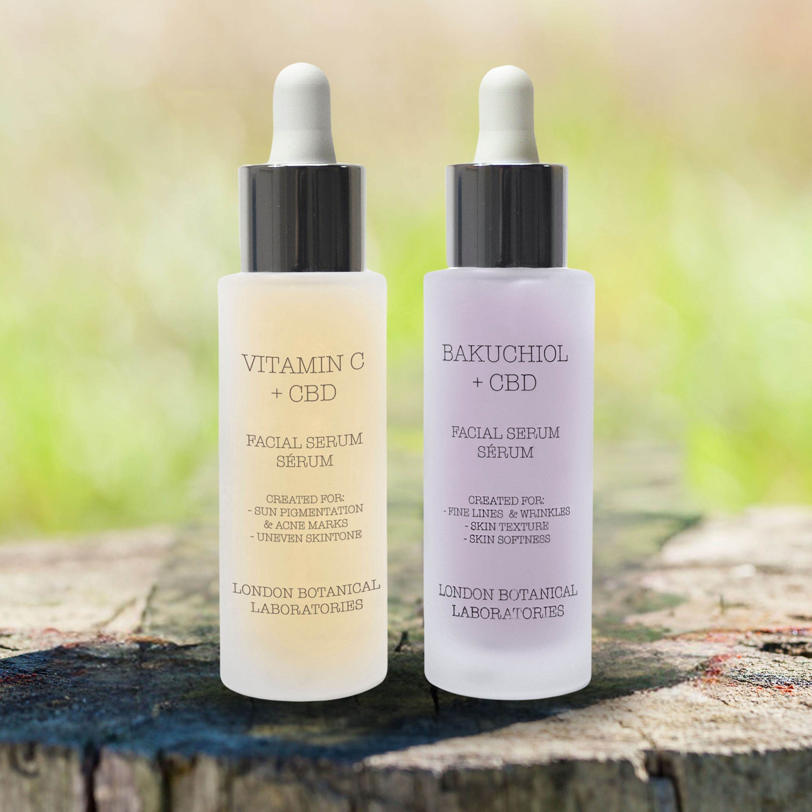 Due flaconi di siero viso, Vitamina C + CBD e Bakuchiol + CBD, su una superficie di legno con sfondo sfocato.
