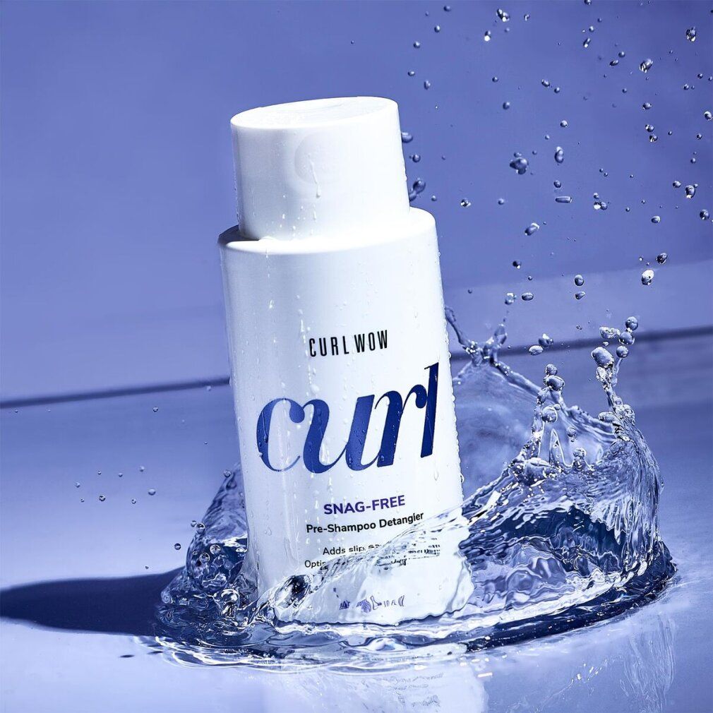 Flacone bianco con spruzzi d'acqua. Scritta: CURL WOW, curl, SNAG-FREE Pre-Shampoo Detangler. Sfondo blu.