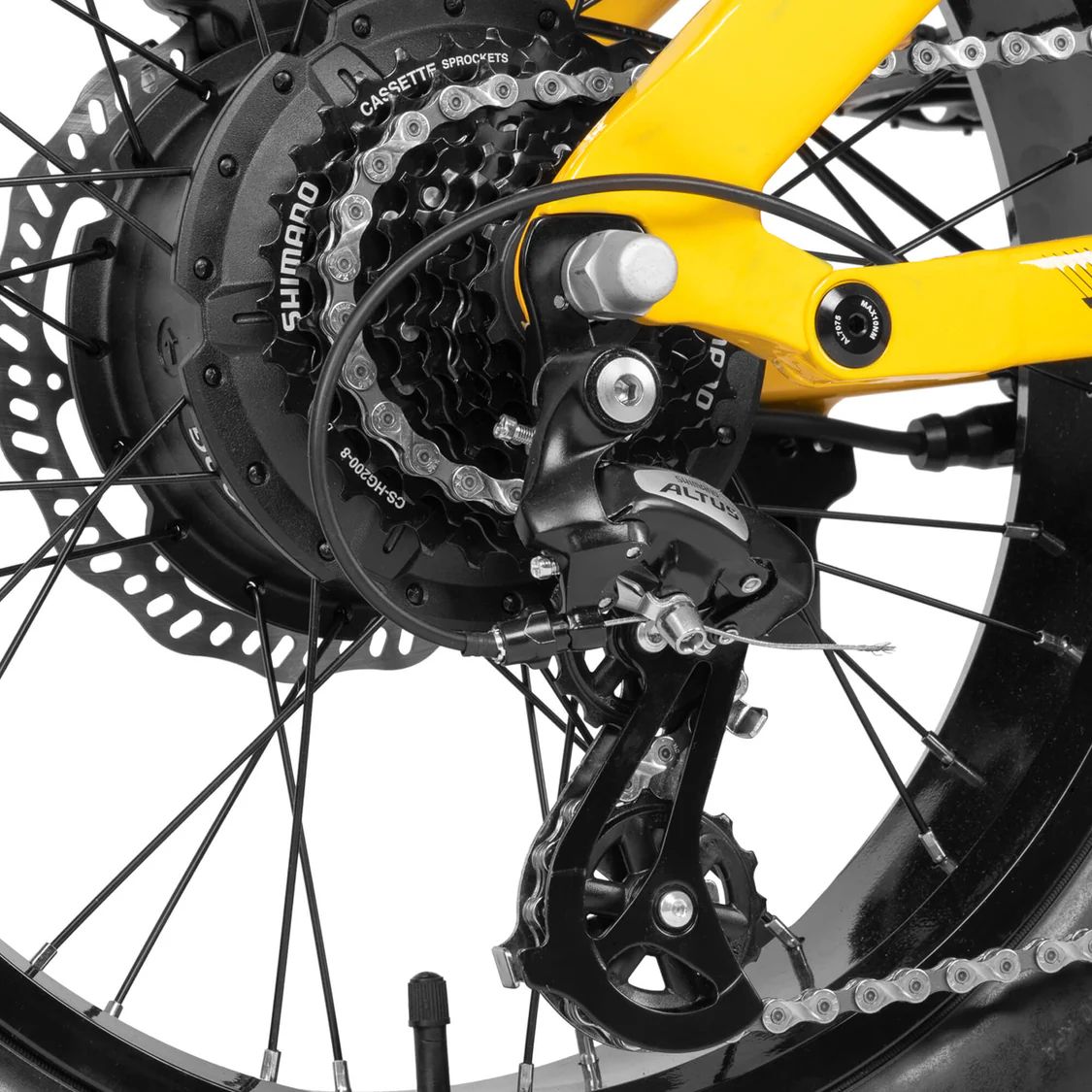 Primo piano della ruota posteriore di una e-bike. Deragliatore Shimano, catena, disco freno.