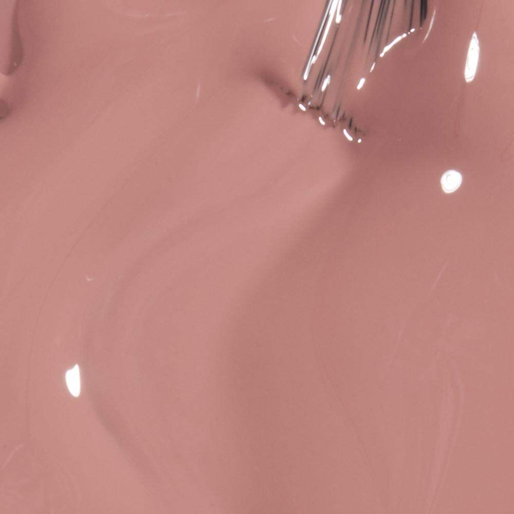 Primo piano di smalto rosa con pennello. Superficie lucida, riflessi chiari.