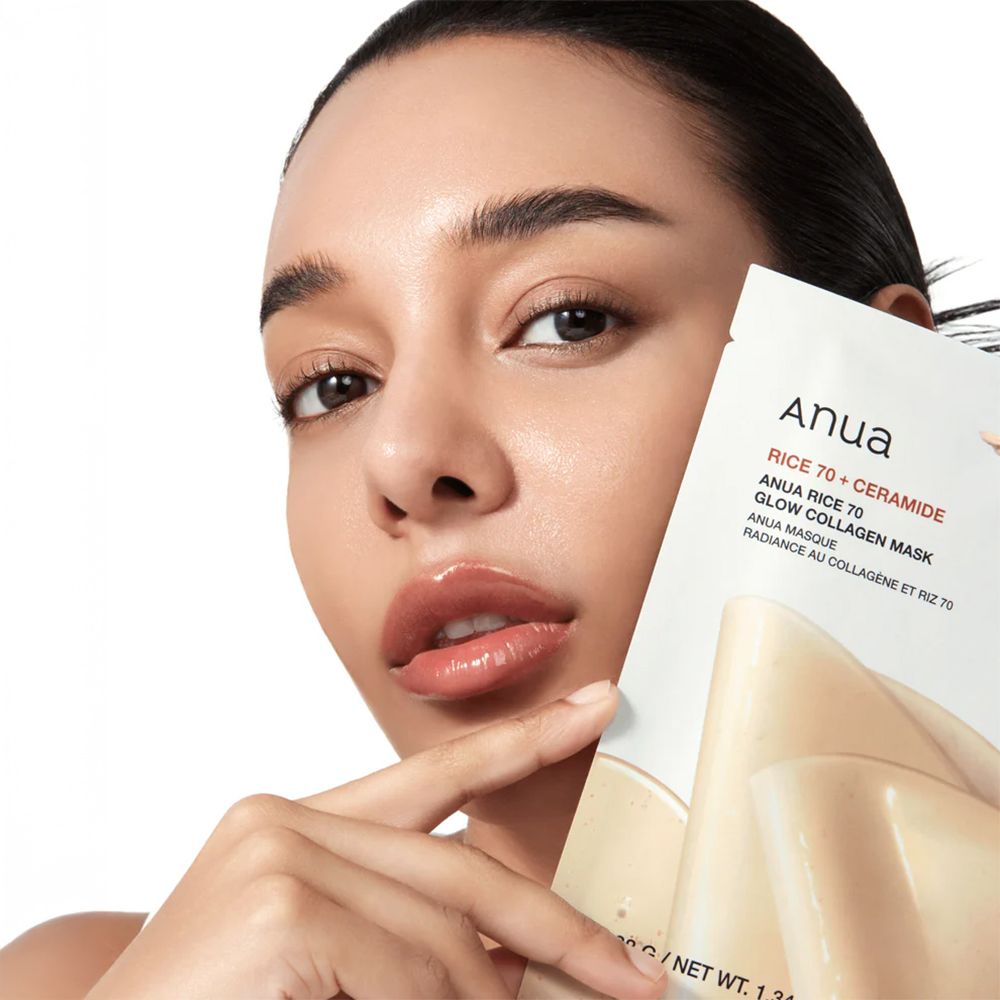 Donna che tiene la maschera Anua Rice 70 Glow Collagen. Viso con maschera. Testo: Anua Rice 70 + Ceramide.