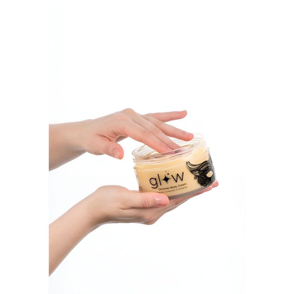 Mani che tengono un barattolo con coperchio dorato. Scritta "glow Shimmer Body Cream".