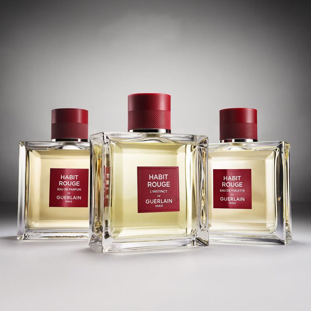 Tre flaconi Eau de Toilette. Flaconi quadrati con tappo rosso. Etichette rosse con nome del prodotto.
