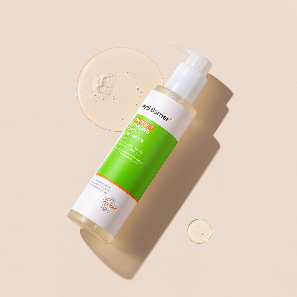 Flacone bianco-verde con dosatore e gocce di liquido. Testo: Real Barrier, Control-T Cleansing Foam. Logo Sebomide.