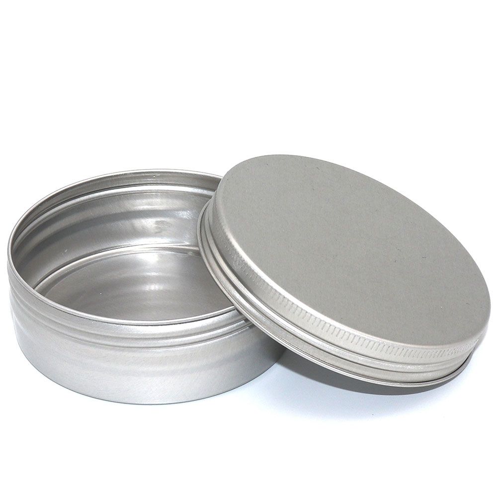 Contenitore rotondo Lamazuna in metallo argentato per shampoo solido. Il coperchio è posizionato accanto. Il contenitore ha un diametro di circa 8 cm ed è realizzato in metallo.