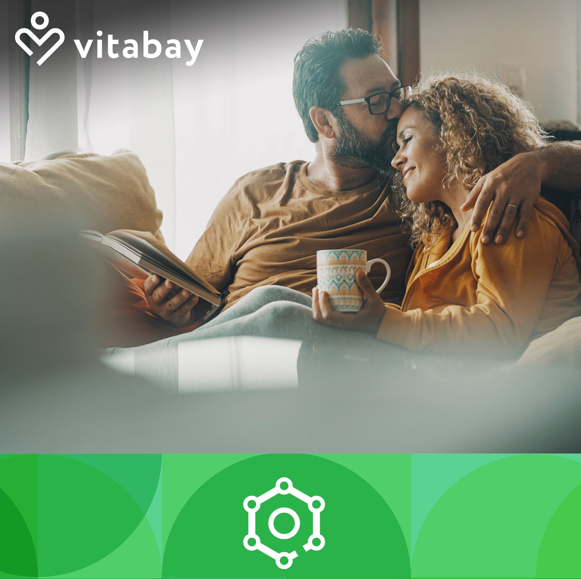 Un uomo e una donna seduti su un divano. La donna tiene una tazza. Sullo sfondo cerchi verdi e il logo Vitabay.