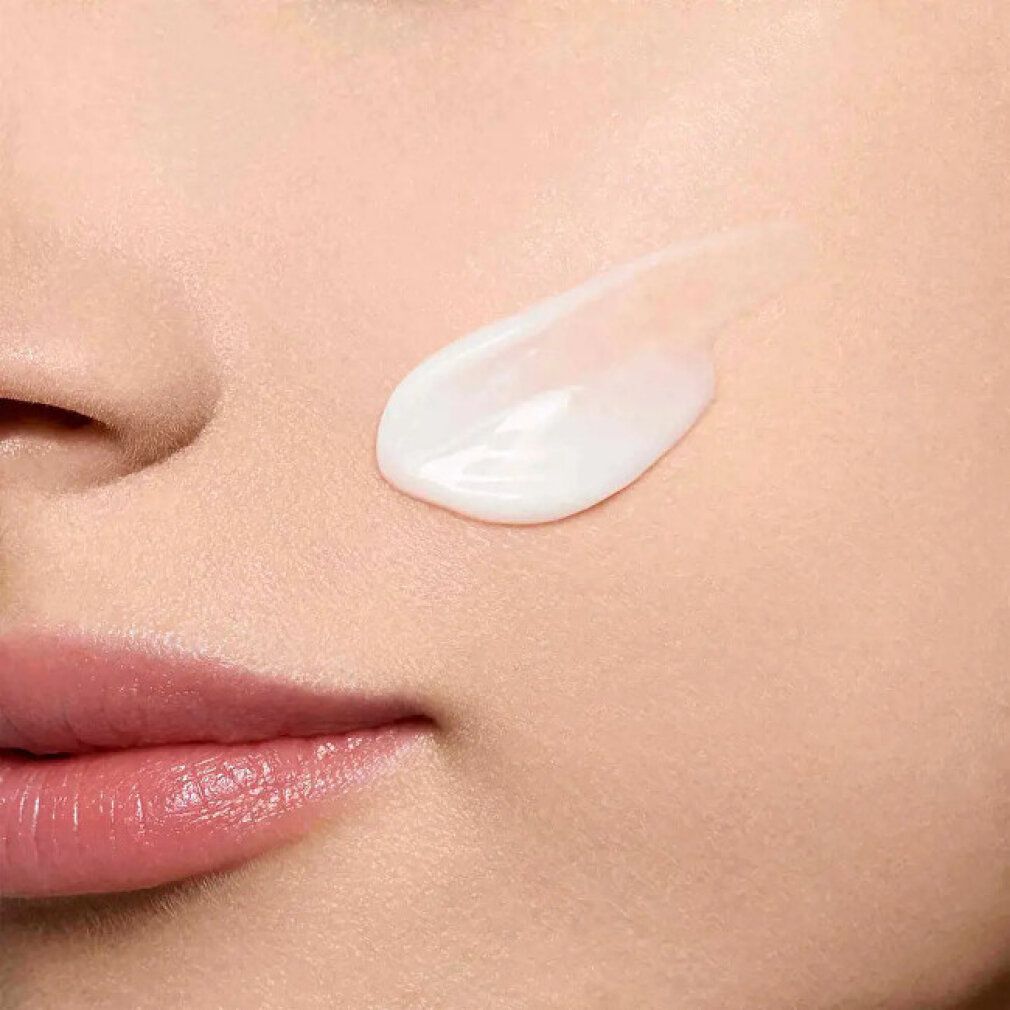 Primo piano della pelle con crema applicata. Filo di crema sulla pelle. Parte del viso con naso, labbra e guance.