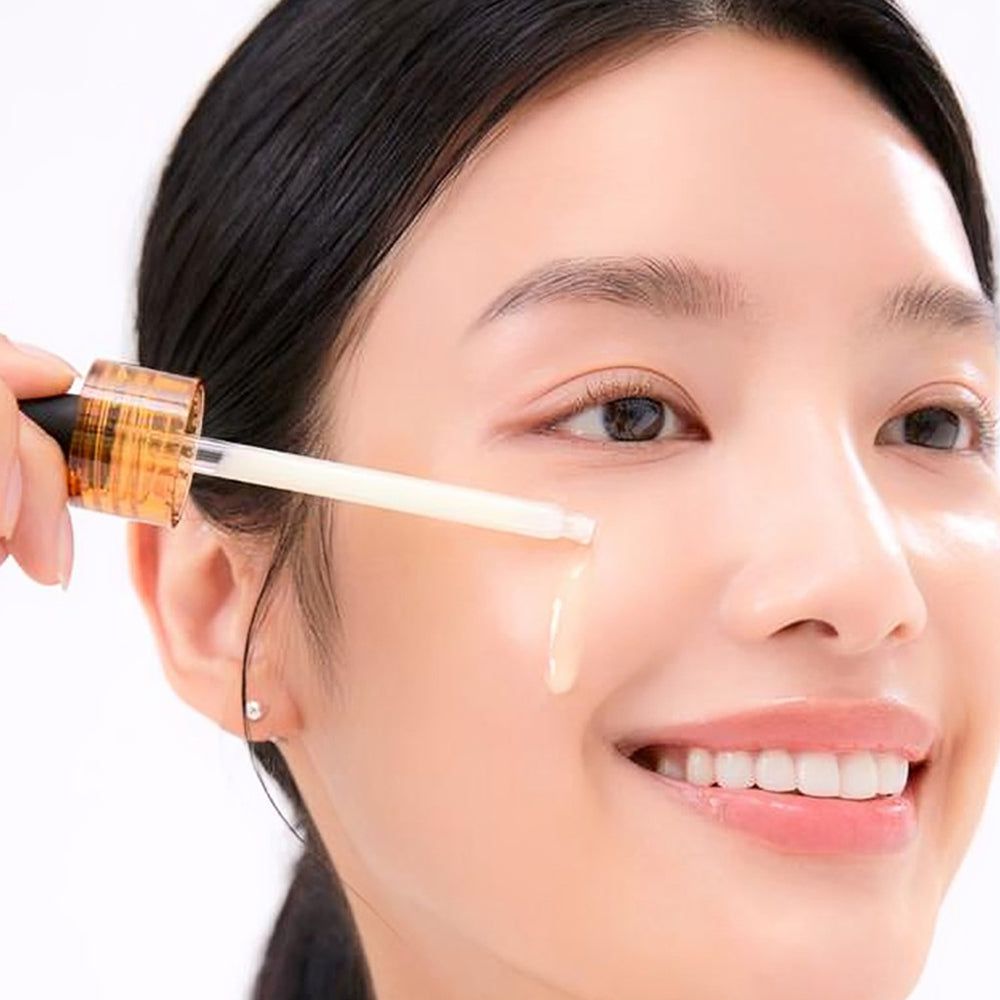 Donna che applica liquido sulla pelle con un contagocce. Visibile: flacone con scritta Vitamin Derma Ampoule Brightening, MEDIHEAL.