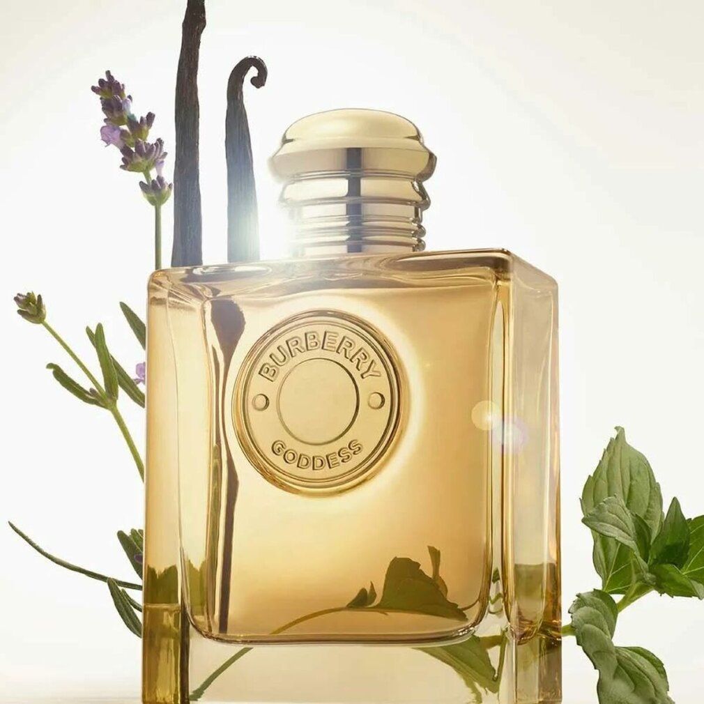 Burberry Goddess Intense Eau de Parfum. Flacone quadrato con tappo dorato. Emblema logo. Lavanda, vaniglia e foglie sullo sfondo.