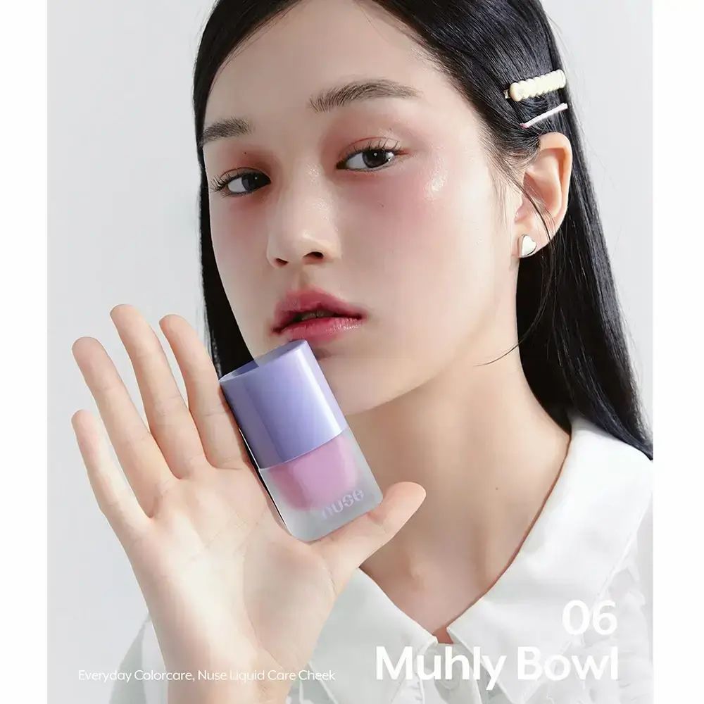 Donna tiene flacone di fard. Tonalità 06 Muhly Bowl. Coperchio lilla, contenuto rosa. Marchio NUSE.