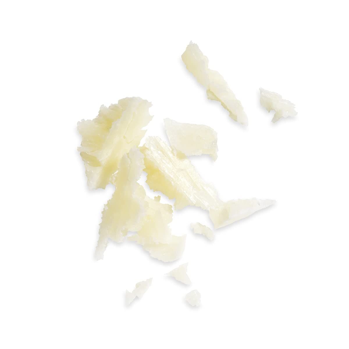 Mucchio di frammenti di sapone giallo chiaro, di forma irregolare, su sfondo bianco. Alcuni pezzi sono rotti.