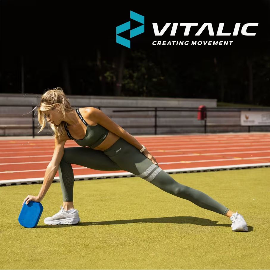 Blocco yoga blu in schiuma. Donna in posa yoga, blocco come supporto. Logo VITALIC sullo sfondo.