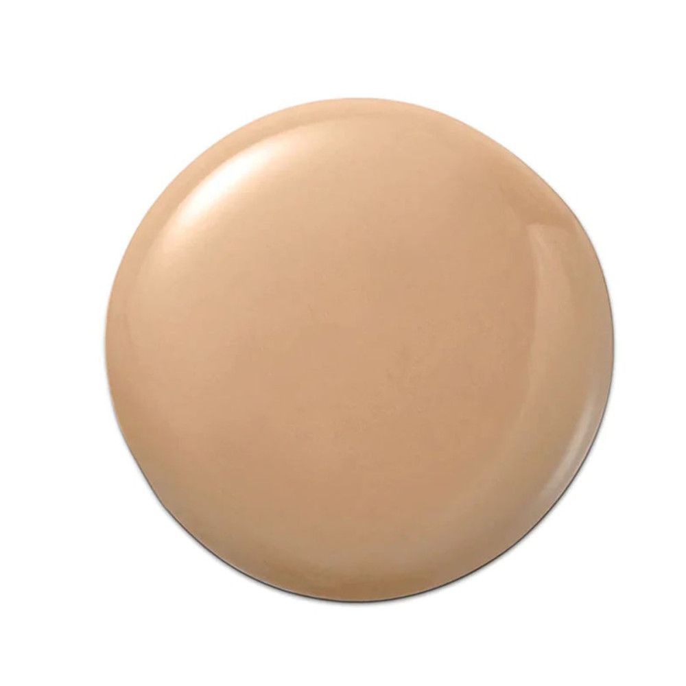 Goccia di fondotinta liquido chiaro su sfondo bianco. Forma rotonda con superficie lucida.